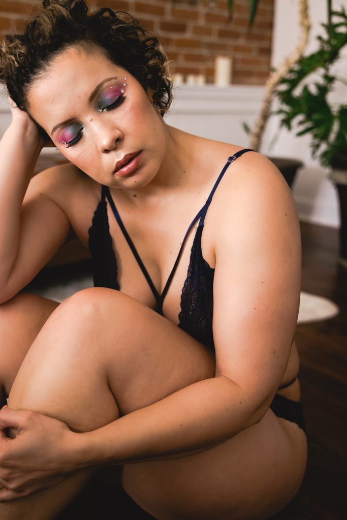 Woman in black lingerie with colorful makeup for a Euphoria inspired boudoir session in Kansas City. 