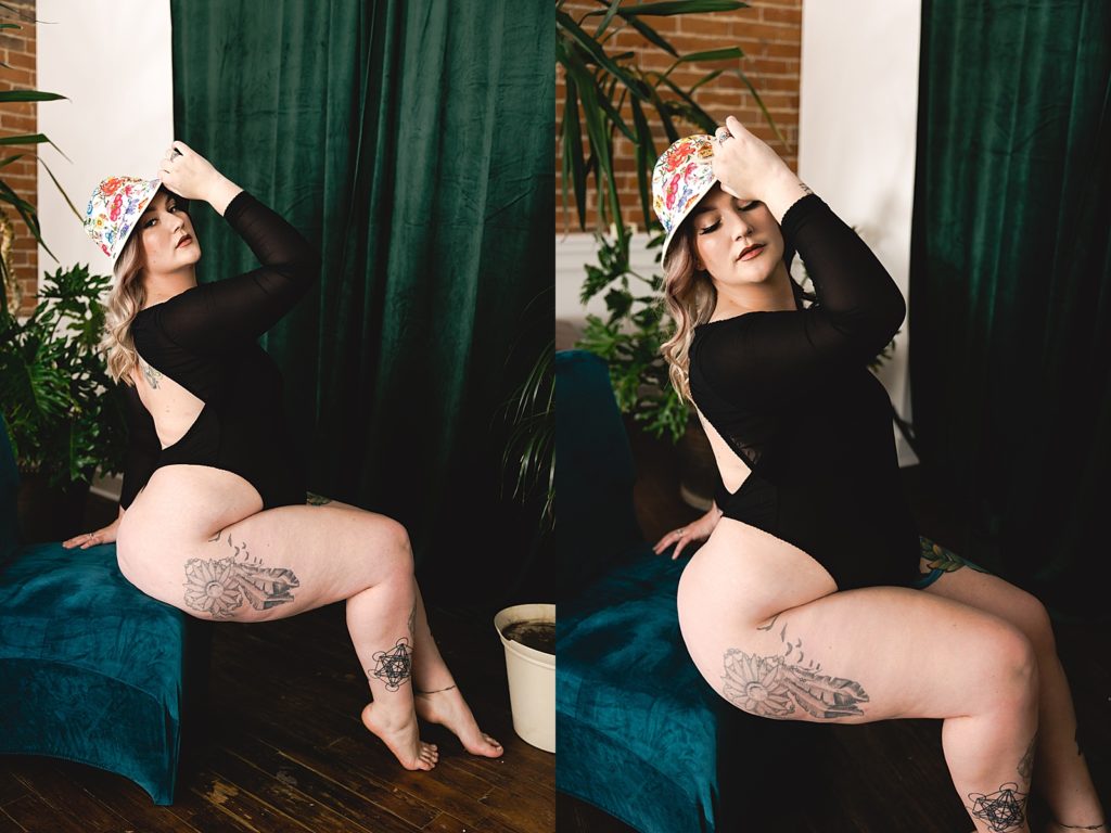 Woman in black bodysuit and bucket hat sitting at a boudoir studio with WMNKND photographer in Kansas City.