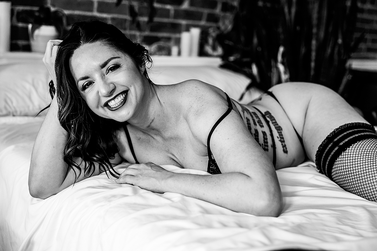 Woman in lingerie lying on a bed at boudoir studio in Kansas City